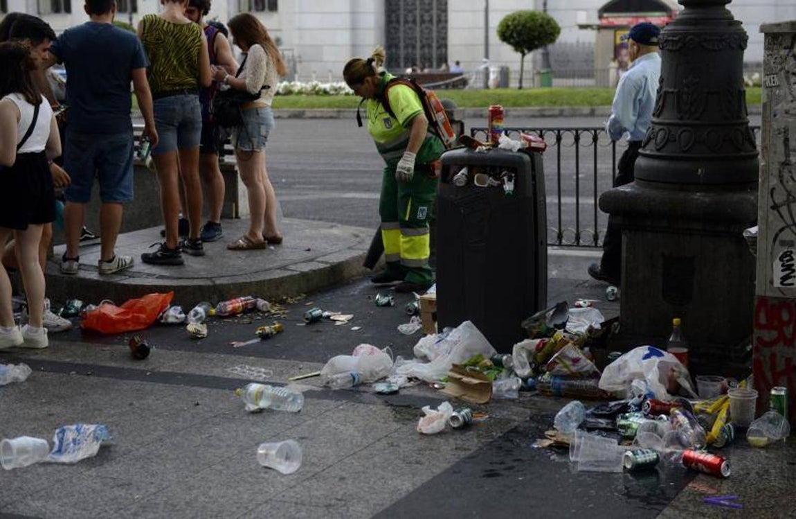 7. Los servicios municipales de limpieza se han mezclado esta mañana con aquellos que regresaban de fiesta. En la imagen, aspecto que presentaba esta mañana el acceso al línea 2 de Metro de Banco de España, en la calle de Alcalá