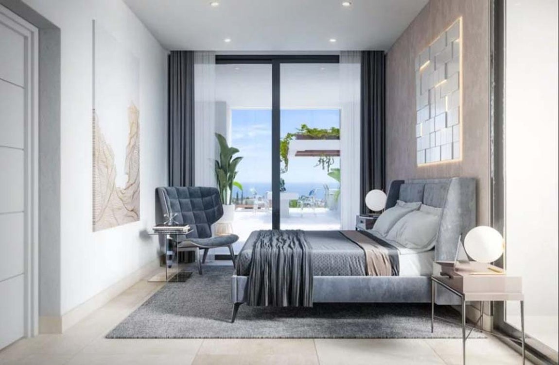 Dormitorio. Los dormitorios ya se encuentran en la planta de arriba, y todos cuentan con acceso a una coqueta terraza privada, con insuperables vistas al entorno. La decoración sigue en la línea del resto de estancias: suelos y paredes blancas, al igual que puertas, y tanto la ropa de cama como el mobiliario apuestan por el gris y visibles vigas de madera que se encuentran repartidas por toda la casa.