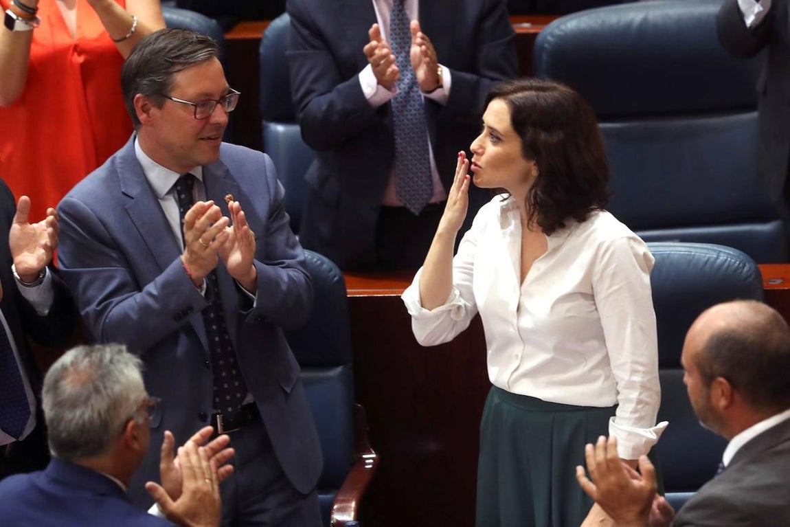 Isabel Díaz Ayuso saluda a la tribuna de invitados en un momento del pleno de investidura. 