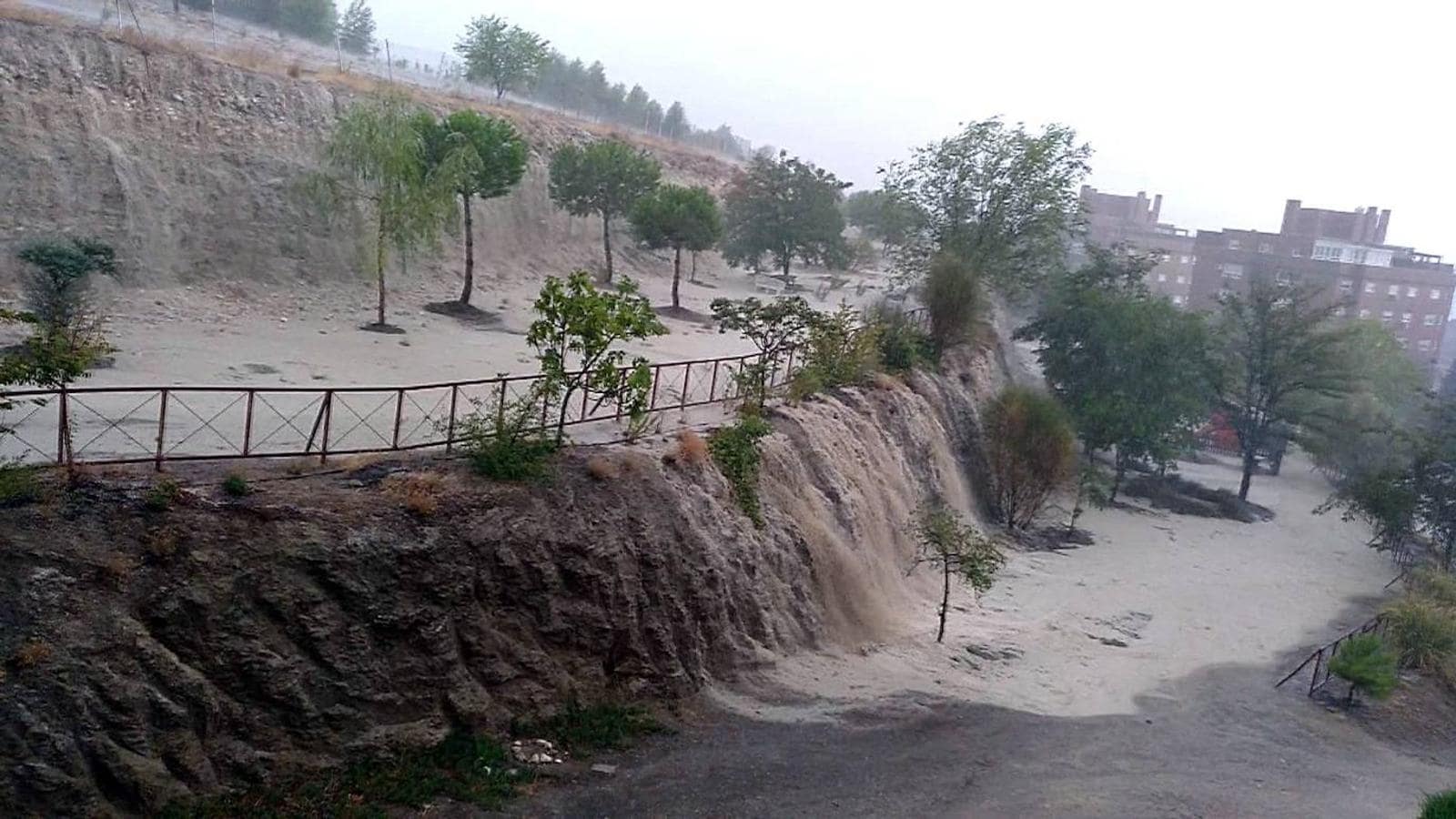 Grandes cantidades de agua caen por la ladera de un parque en Rivas Vaciamadrid. 