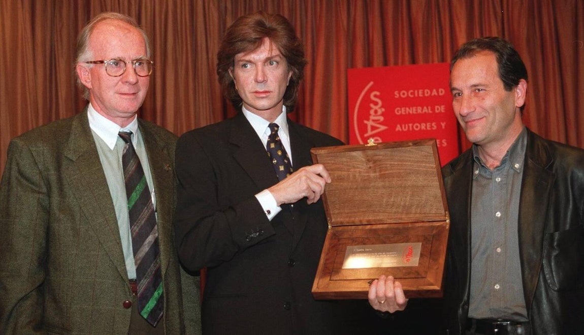 1997: Camilo Sesto muestra la placa conmemorativa que le ha entregado el presidente de la Sociedad General de Autores Eduardo Bautista y el director general de BMG Ariola, José María Cámara, en reconocimiento a su carrera musical como cantante, compositor, productor y arreglista. (Foto de EFE). 