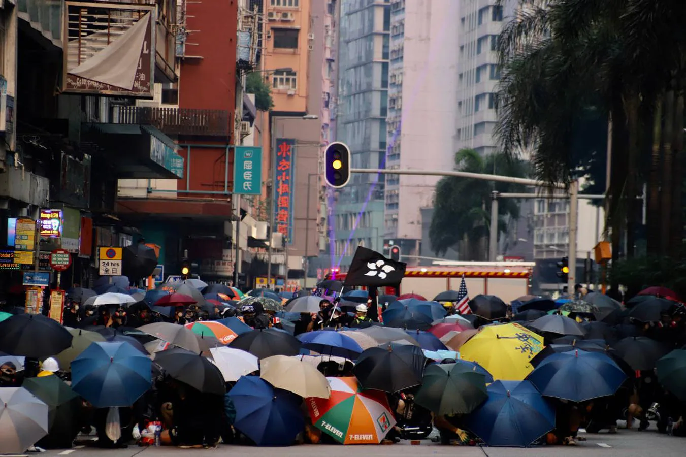 Parapetados bajo sus paraguas al modo de la «tortuga romana», los manifestantes ondean la «Bauhinia negra», bandera de las protestas que cambia el rojo original de la enseña de Hong Kong. 