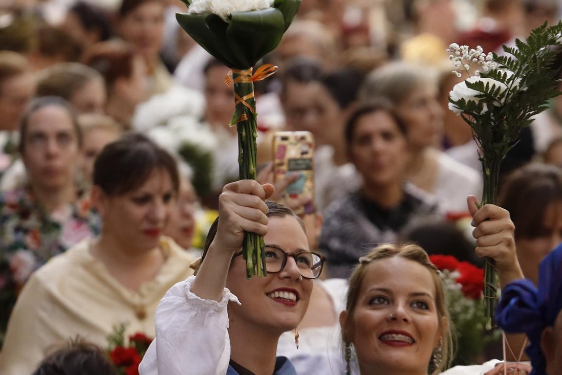 Emoción compartida. Dos jóvenes levantan sus ramos, emocionadas, al aproximarse a la imagen de la Virgen del Pilar