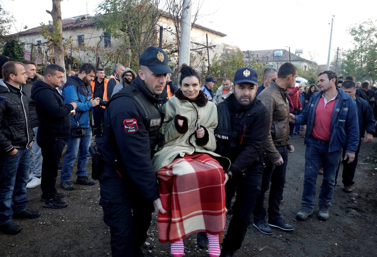 Los trabajadores de emergencia cargan con una mujer rescatada tras el terremoto. 