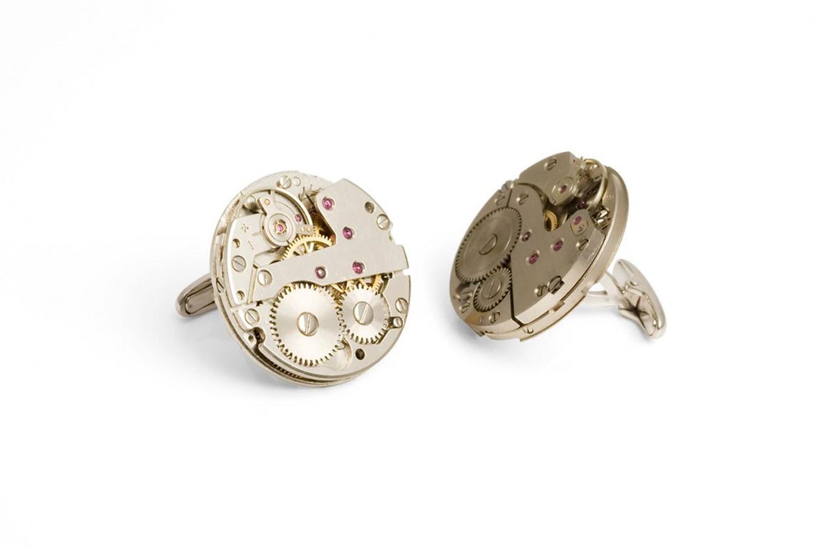 Gemelos Máquina de reloj Huomo. Fabricados en oro amarillo, acero y rubí, y con auténticas maquinarias de reloj mecánico, estos gemelos redondos de Nicol’s son joyas únicas. Con cierre submarino, pueden llevarse en camisas de puño doble o sencillo, y son ideales para un hombre elegante y con personalidad. Precio: 2.637,60 €