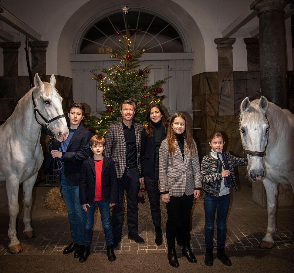 La Familia Real danesa ha escogido la imagen más navideña de todas, posando con un árbol de Navidad y sus caballos. 