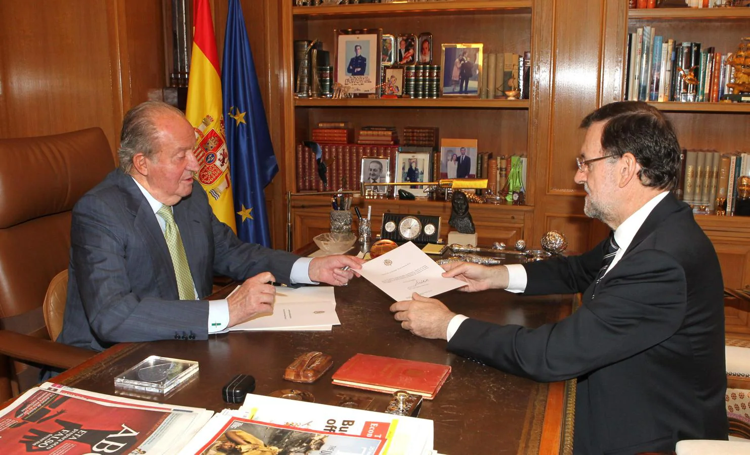 Juan Carlos I firmando en 2014 su abdicación con el entonces presidente del Gobierno, Mariano Rajoy. 