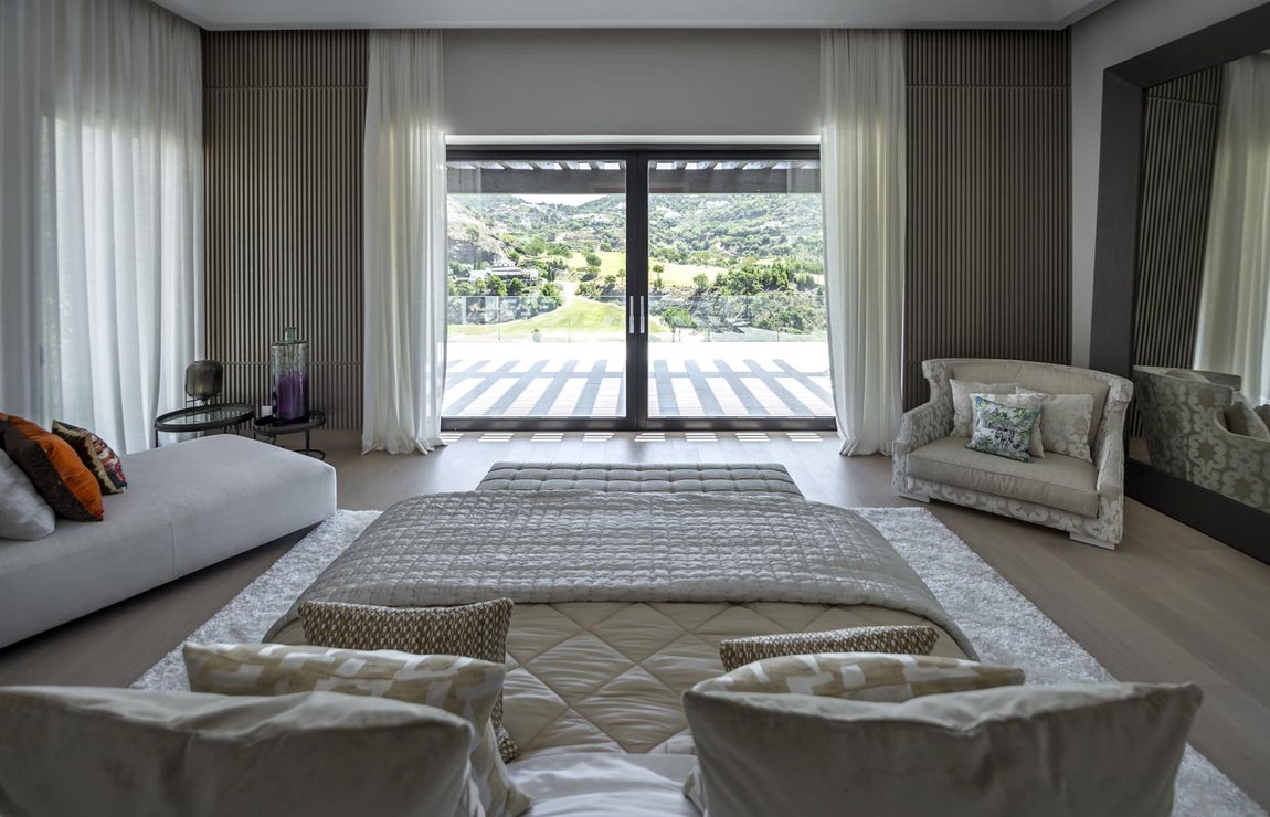 Ibiza Breeze House:14,5 millones de euros. Tiene una superficie de 3.000 m2 construidos distribuidos en tres plantas y se levanta sobre una parcela de más de 8.500 m2. Cuenta con 9 dormitorios, 9 baños y 1 aseo, e incluye además dos apartamentos independientes. Entre sus dotaciones más singulares hay una bodega, sala de cine, lavandería totalmente equipada, baño turco, sauna, gimnasio, piscina climatizada con un largo de 18 metros, zona de bar o un garaje para 8 coches. Ya en exterior, alberga varios porches, piscina de 20 metros de longitud, parking y jardín. En la imagen se aprecia la suite principal con vistas al jardín