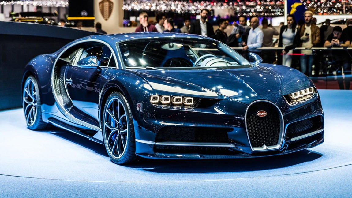 Bugatti Chiron. Motor W-16 de 1,500 hp, exterior Art Deco, e interiores de lujo. Es un coche futurista que se bautizó así para honrar al piloto  Louis Chiron. Es, a su vez, una reencarnación moderna del Bugatti Type 57 SC Atlantic de los años treinta