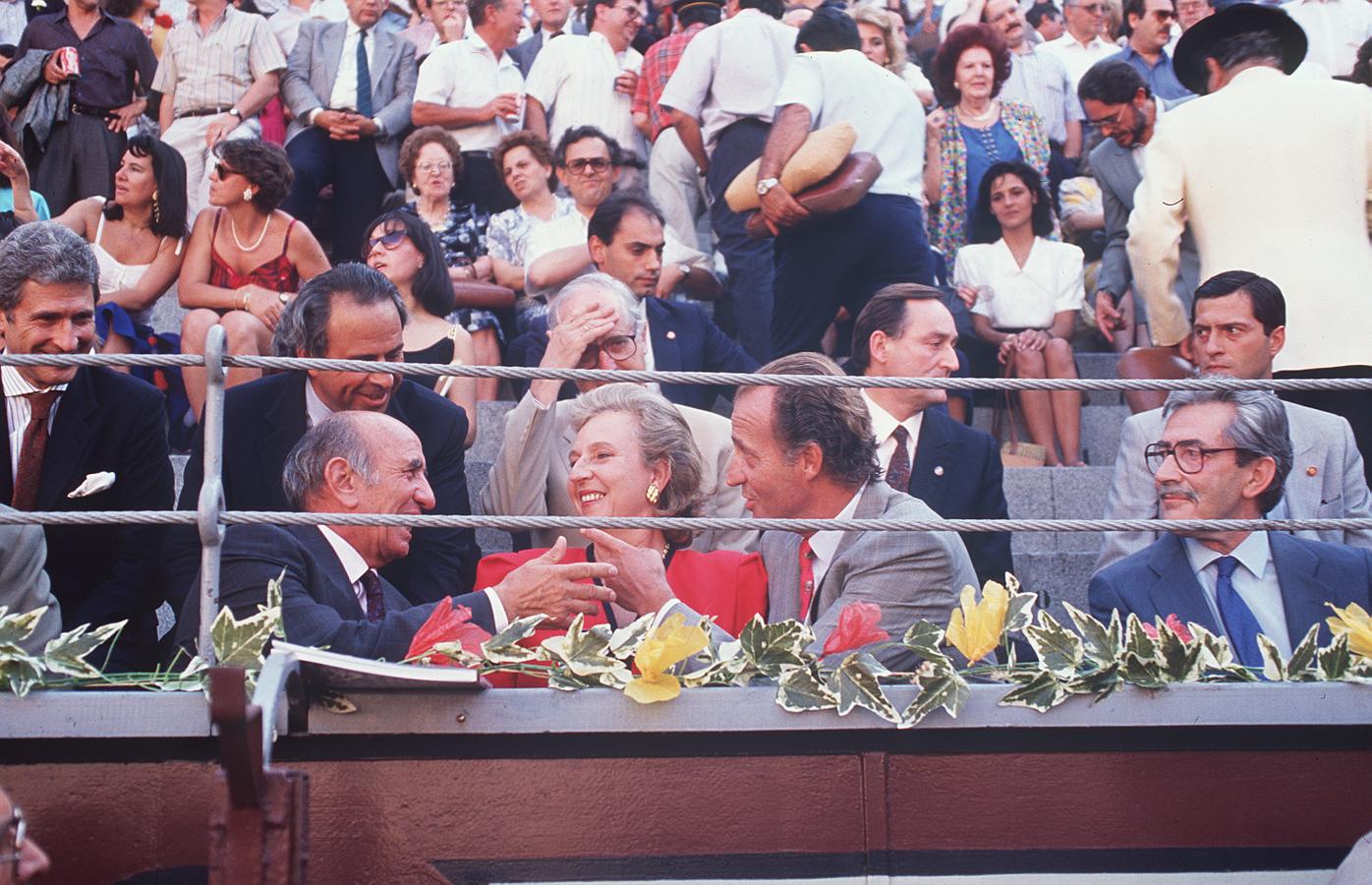 El Rey Don Juan Carlos, la Infanta Doña Pilar de Borbón y el ganadero Victorino Martín conversan animadamente al comienzo de la Corrida de la Prensa, en la madrileña Plaza de las Ventas, en 1990