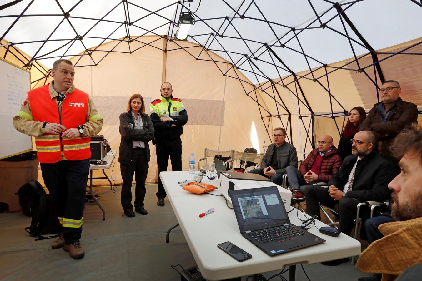 El responsable de Interior del gobierno catalán y el de bomberos explican en el puesto de mando la evolución del incidente a los periodistas. 