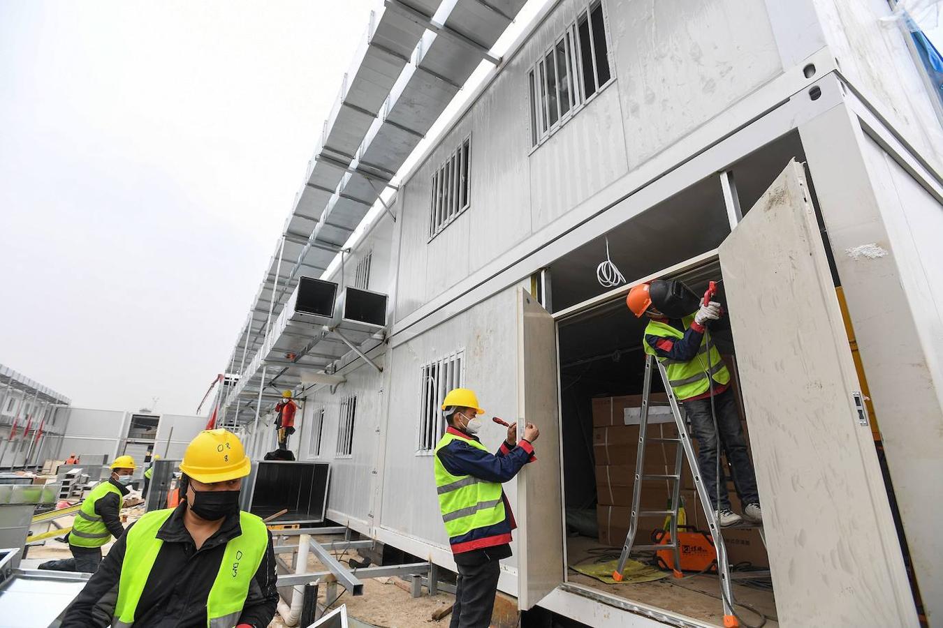 Los empleados chinos trabajan en la construcción del hospital Huoshenshan, que significa «Montaña del Dios del Fuego». 