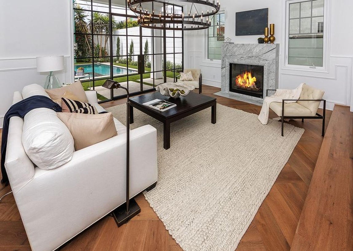 Hancock Park. En el salón se repiten las constantes estéticas qur armonizan la vivienda de Margot Robbie. La luz es la protagonista de la estancia y se adueña del espacio a través de las puertas que dan al patio interior, donde hay una piscina y un pequeño jardín