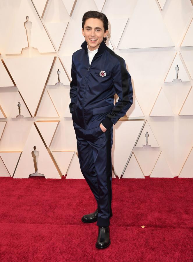 Timothée Chalamet. El actor es asiduo a romper con las normas estilísticas impuestas y en esta ocasión no ha hecho una excepción. Chalamet escogió un traje de color azul con aires deportivos firmado por Prada con joya de Cartier en uno de los bolsillos superiores que sin duda no pasó desapercibido, un broche de Alta joyería de Cartier Tradición en oro blanco, platino, rubíes y diamante.