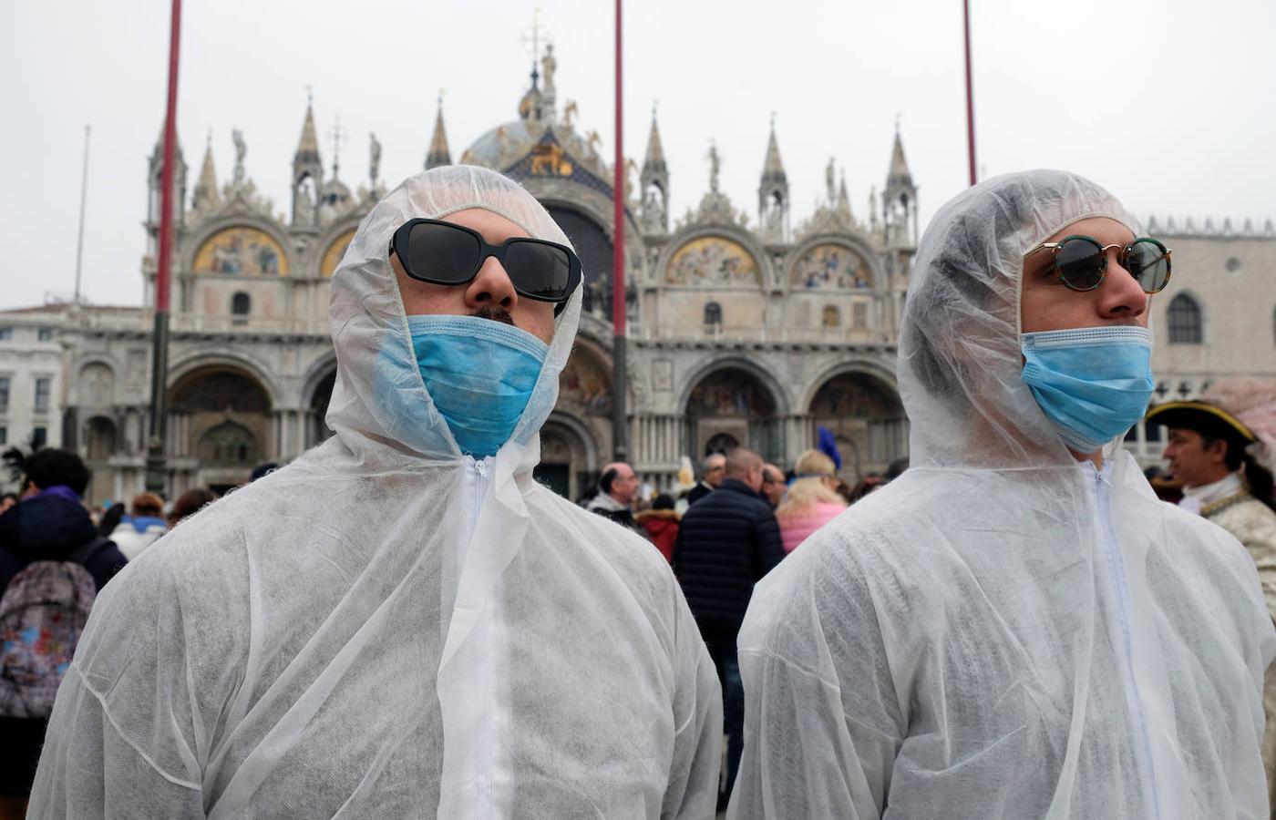 Dos turistas usan mascarillas protectoras en el carnaval de Venecia. 