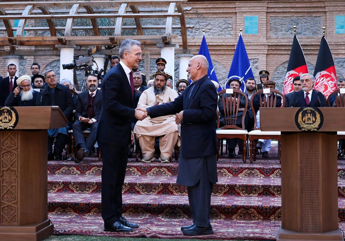 El secretario general de la OTAN, Jens Stoltenberg (izd.), junto al líder talibán, el emir Hebatulá Ajundzada, tras la firma del acuerdo de paz hoy en Doha
