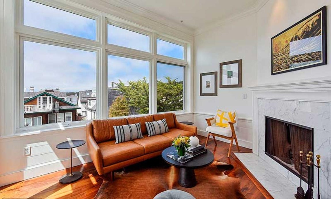 Así es la nueva casa de Julia Roberts en San Franciso. La vivienda cuenta con varios salones y zonas de ocio. Espacios con chimenea, como la de mármol blanco de la imagen, para relajarse tras un largo día al calor del fuego. Sus muebles de estilo contemporáneo, como el sillón de cuero marrón o las mesas en negro, contrastan con el estilo clásicio de la casa.
