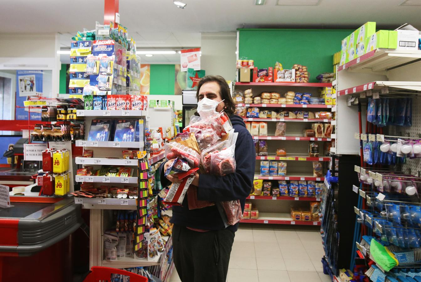 El aprovisionamiento de comida y enseres se ha convertido en una rutina frecuente durante de la cuarentena. En la imagen, un hombre carga en brazos con la compra en un supermercado en Santiago.. 