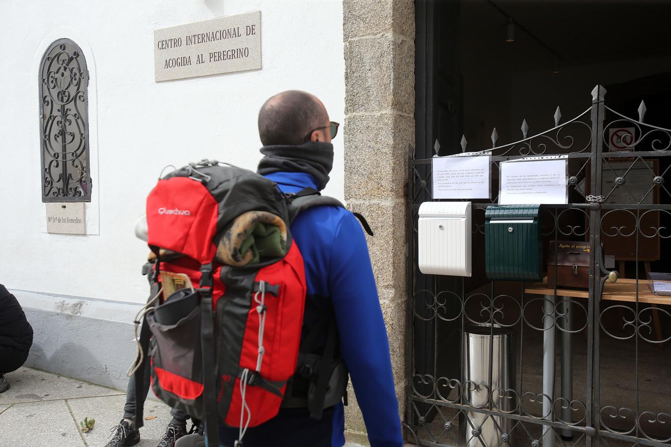 Un peregrino lee el aviso de cierre del Centro Internacional de Acogida al Peregrino en Santiago.. 