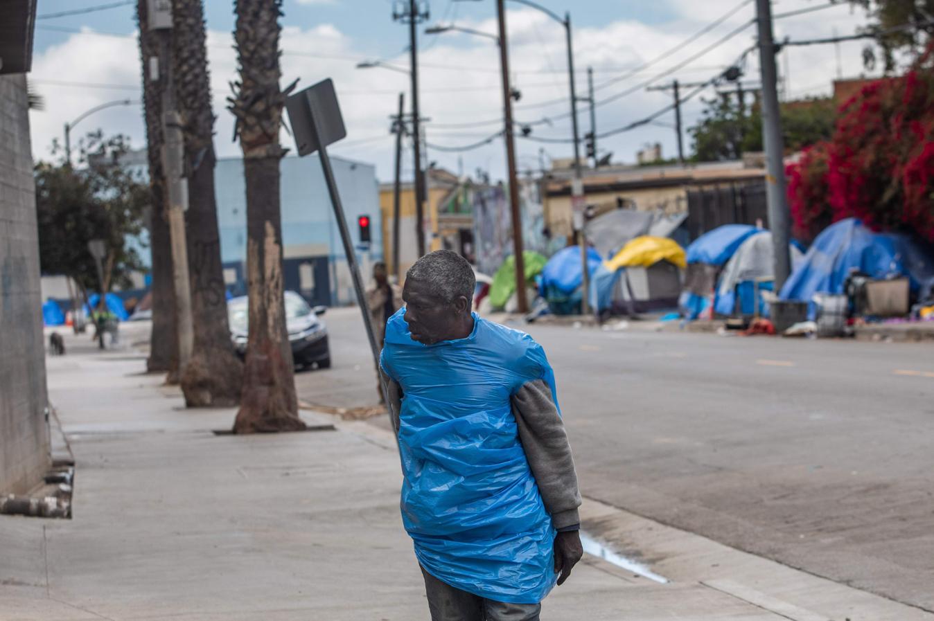 Los Ángeles (EE.UU.). Un sin techo se protege con un plástico de la pandemia que esta afectando con fuerza algunos estados del país