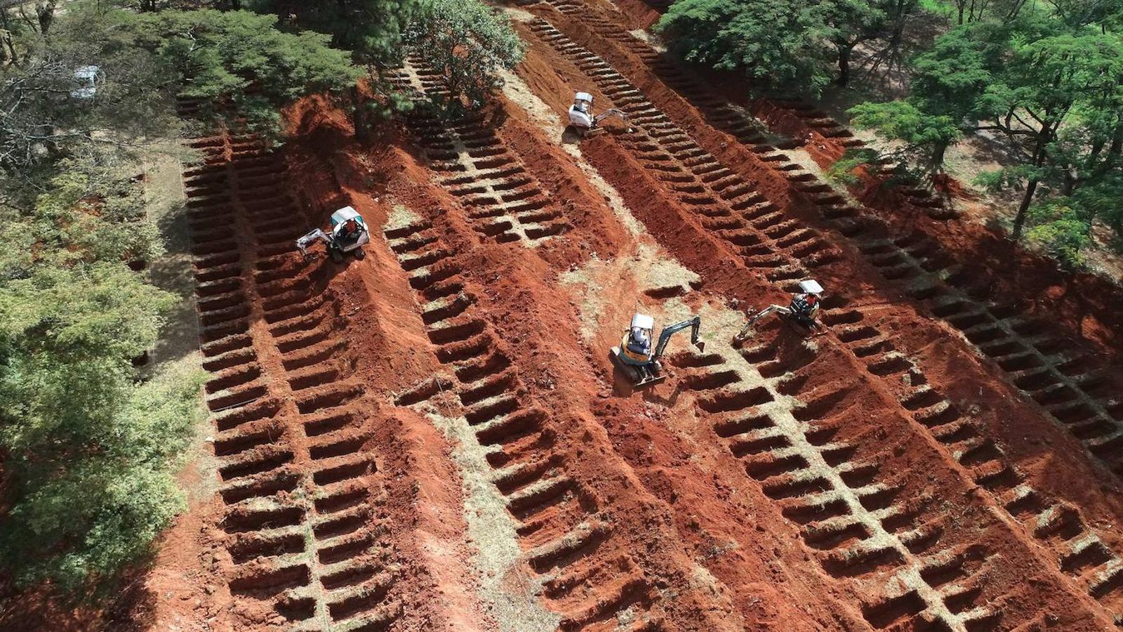 Trabajadores preparan más espacios para las tumbas en el cementerio municipal debido a un aumento previsto de muertes en los próximos días en el estado de Sao Paulo, epicentro de la pandemia en Brasil.. 