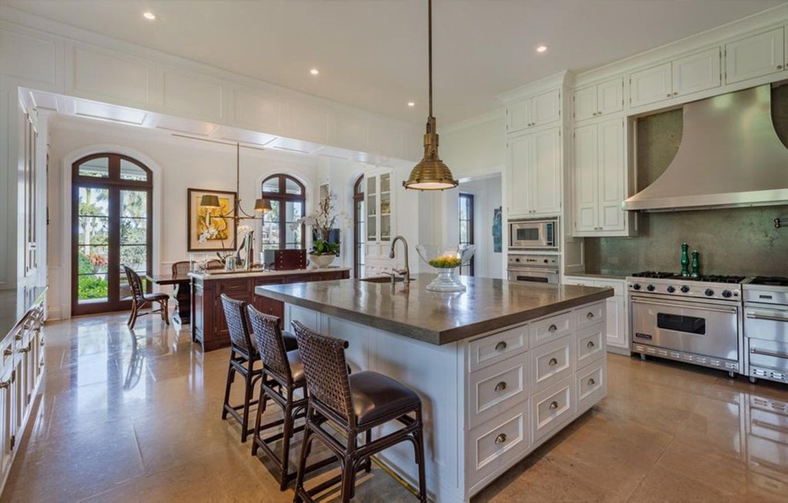 Así es la propiedad de Pharrell Williams en Coral Gables, Miami. La cocina del chef, de concepto abierto, dispone de amplios muebles y una isla con fregadero, espacio de almacenaje y zona de desayuno. Además, un exquisito mueble de madera hace de separación con la zona de comedor.