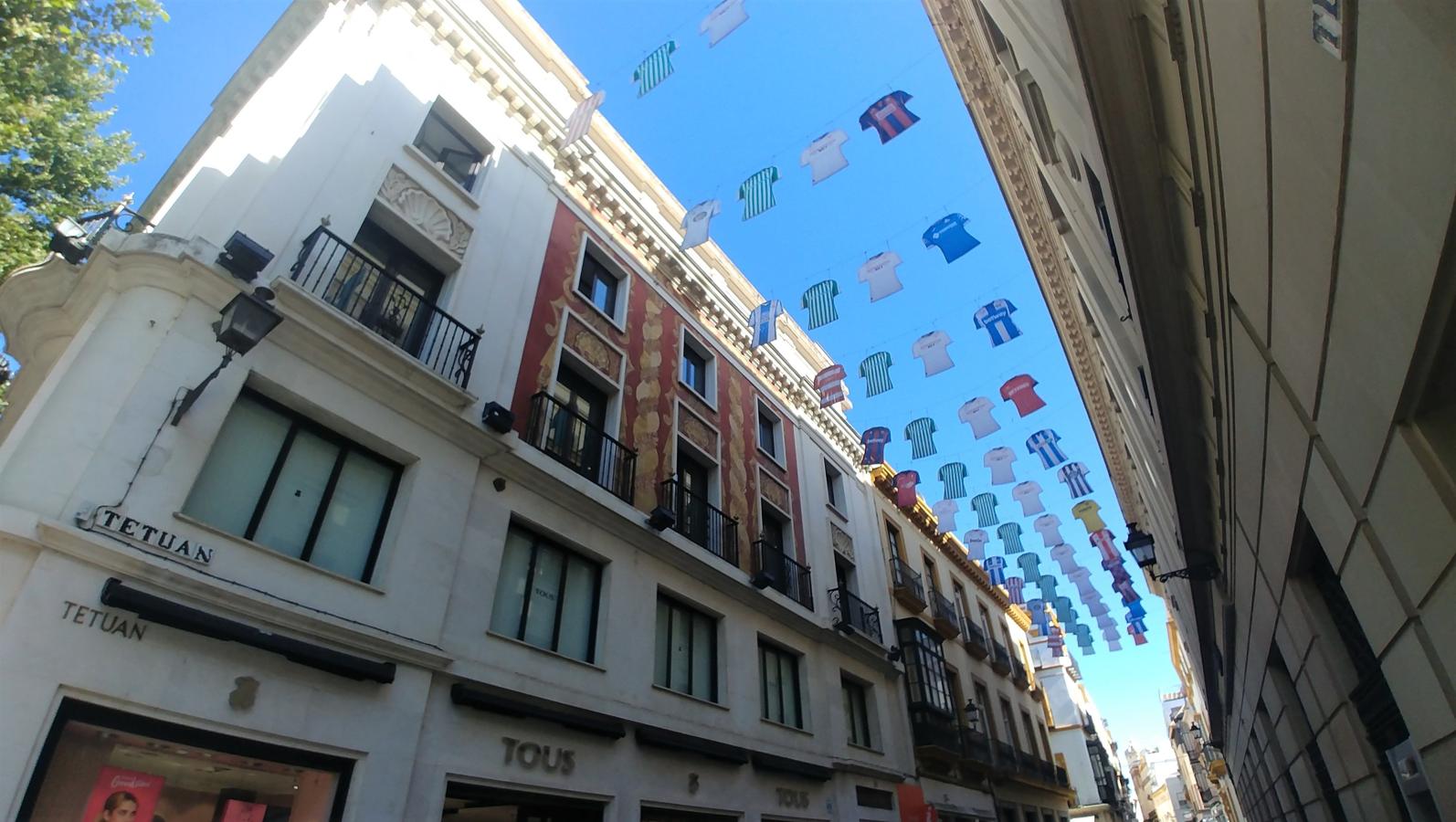 El fútbol calienta motores. La Liga de Fútbol arrancará el próximo jueves para alegría de los aficionados. Uno de los encuentros de esa jornada será el Sevilla-Betis. Por eso, la capital hispalense ha amanecido en una de sus arterias más comerciales decorada con camisetas de distintos equipos