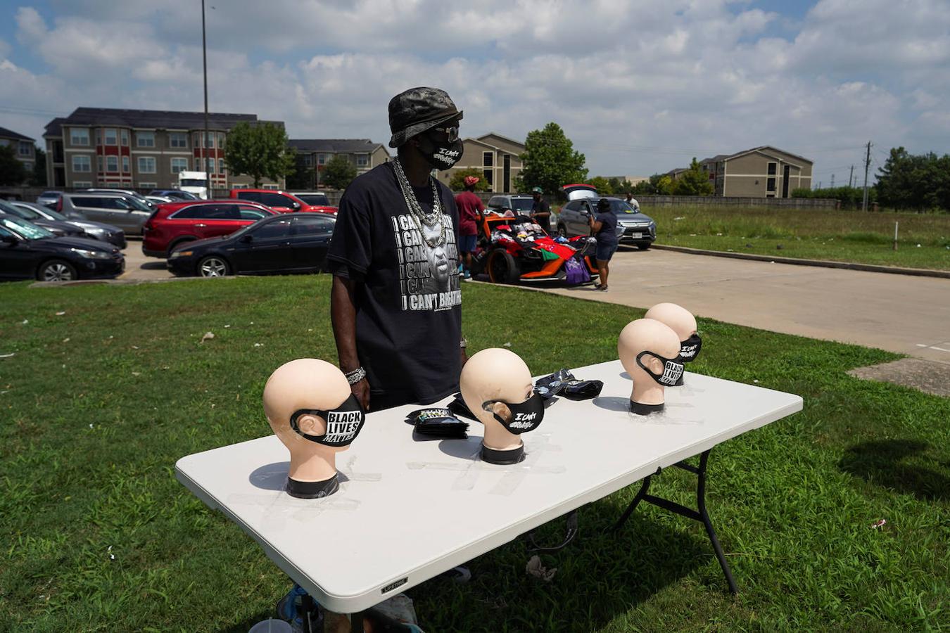 En los alrededores del funeral, una persona vende mascarillas con mensajes «No puedo respirar» y «Las vidas negras importan». 