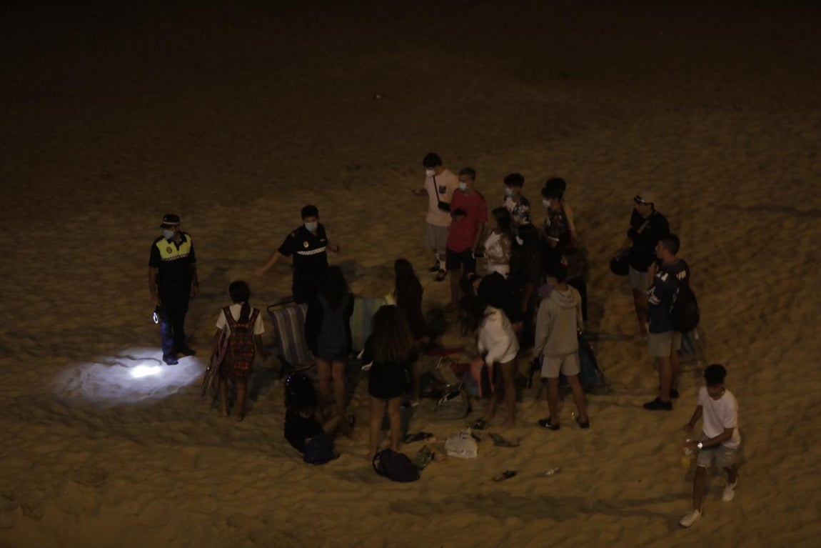 FOTOS: Unos 1.000 jóvenes son desalojados de la playa en Cádiz cuando hacían botellón por San Juan
