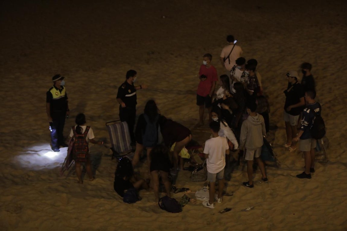 FOTOS: Unos 1.000 jóvenes son desalojados de la playa en Cádiz cuando hacían botellón por San Juan
