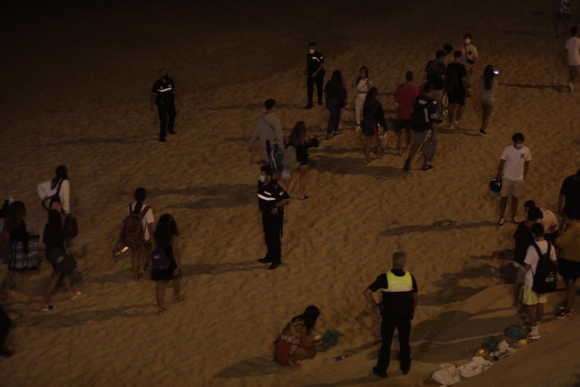 FOTOS: Unos 1.000 jóvenes son desalojados de la playa en Cádiz cuando hacían botellón por San Juan