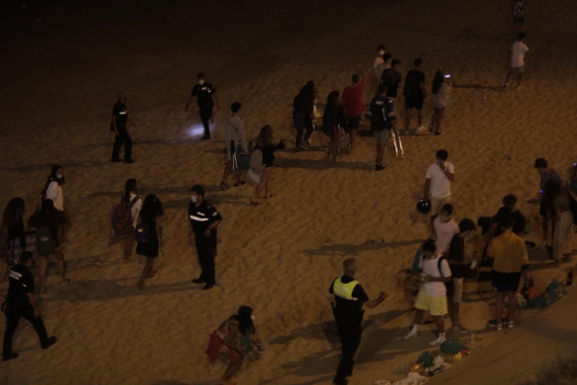 FOTOS: Unos 1.000 jóvenes son desalojados de la playa en Cádiz cuando hacían botellón por San Juan