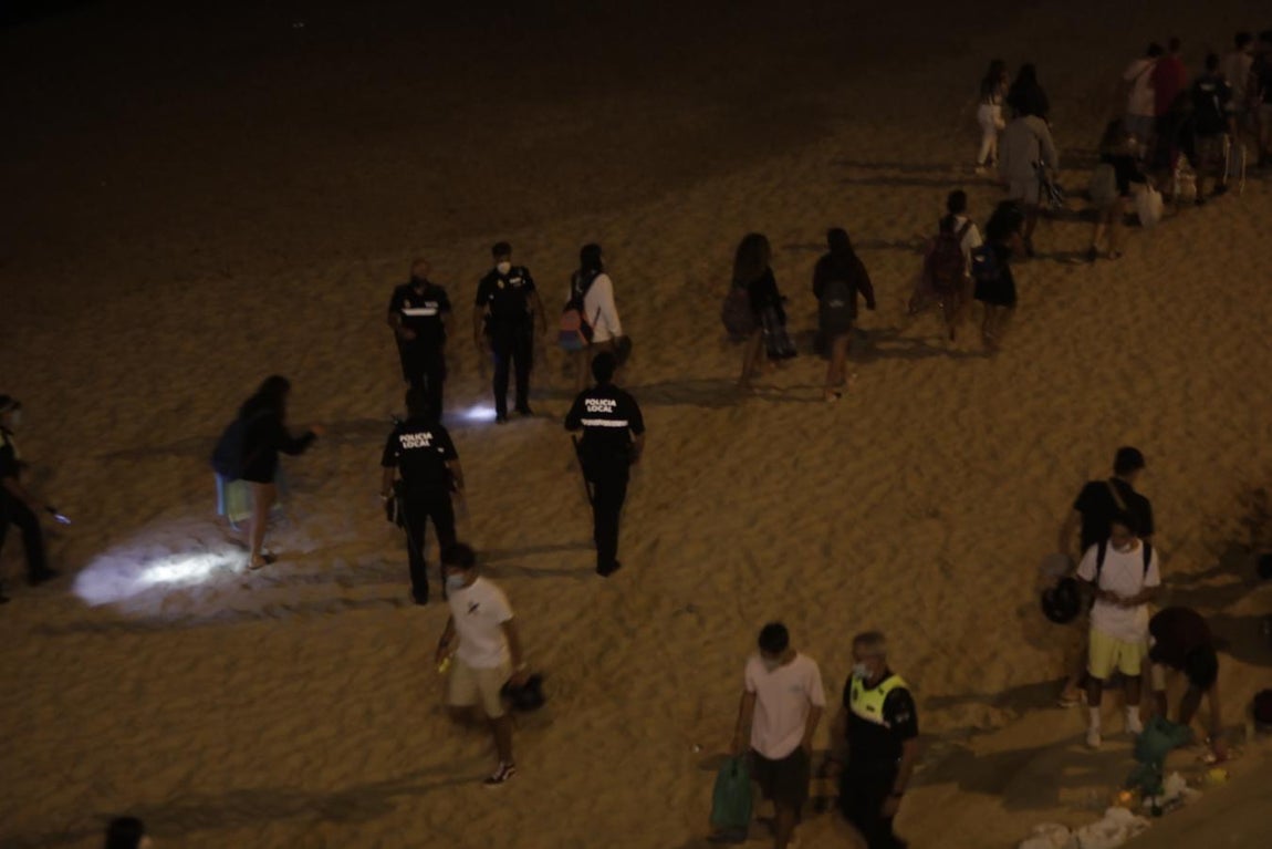 FOTOS: Unos 1.000 jóvenes son desalojados de la playa en Cádiz cuando hacían botellón por San Juan
