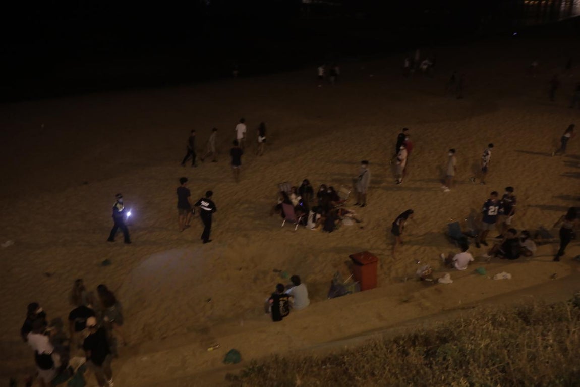 FOTOS: Unos 1.000 jóvenes son desalojados de la playa en Cádiz cuando hacían botellón por San Juan