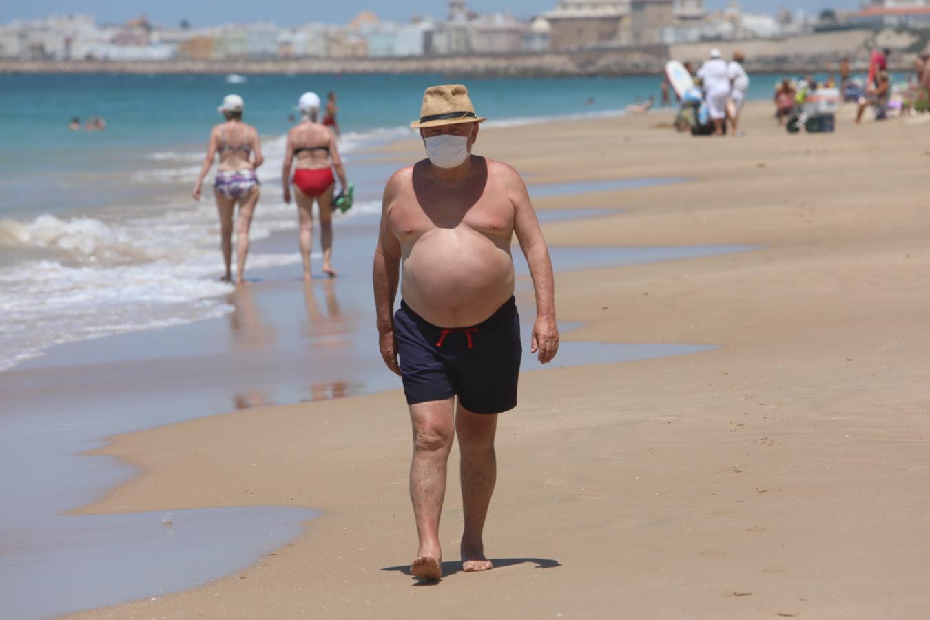 Fotos: Bañistas concienciados en Cádiz con el uso de la mascarilla