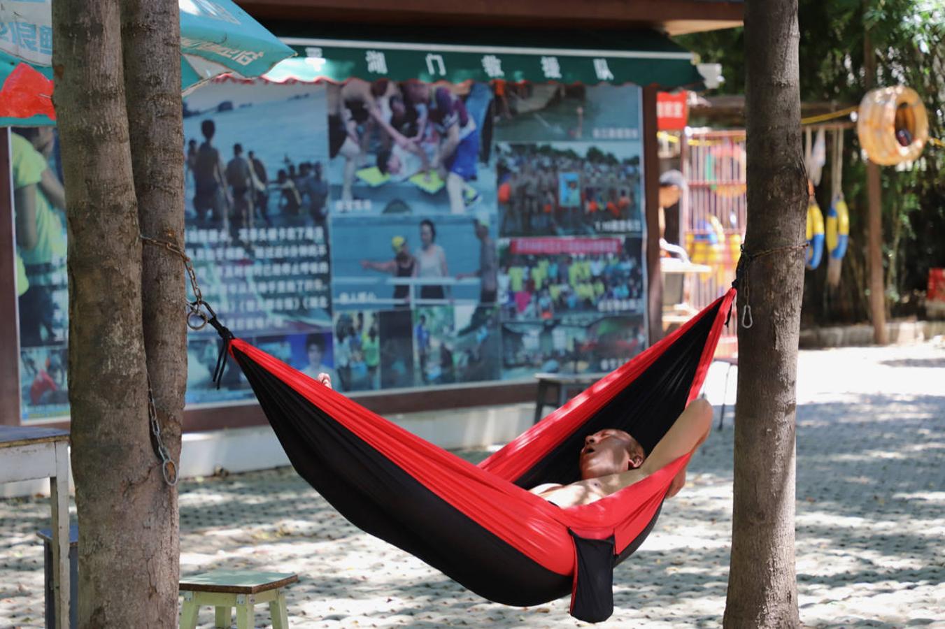 Un bañista echa una siesta tras darse un chapuzón en el río Yangtsé. 