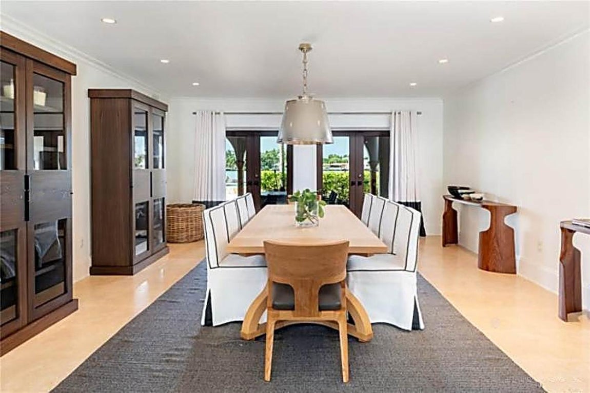 La espectacular mansión de Cher en Miami. El comedor presenta un estilo más sencillo. En este caso las baldosas rústicas se han sustituido por tarima de un tono muy similar al de la mesa para 10 comensales.