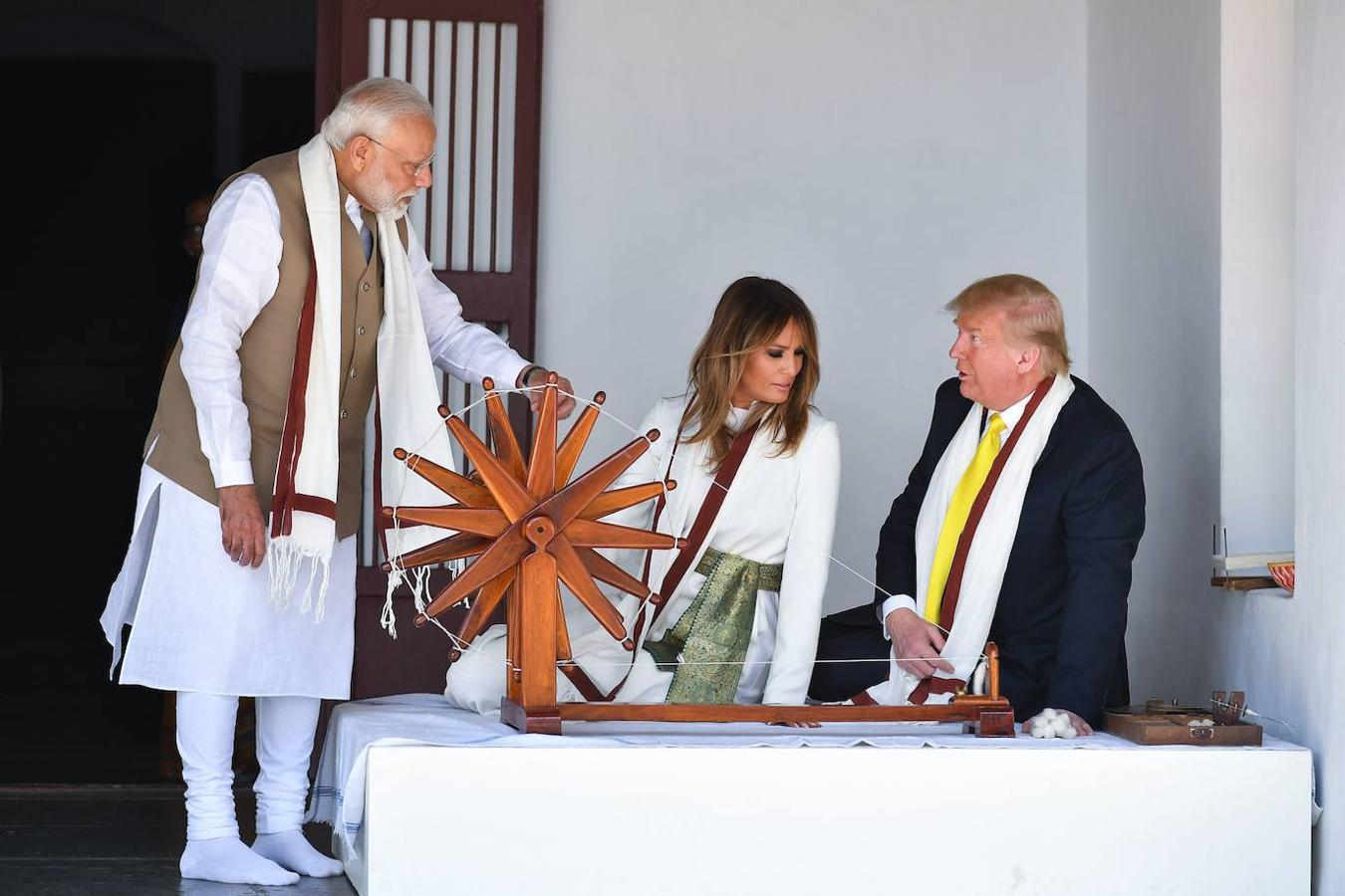 Donald y Melania Trump escuchan al primer ministro indio, Narendra Modi, sentados junto a una «charkha» o rueda de hilar en el marco de su visita a Gandhi Ashram, en Ahmedabad.. 