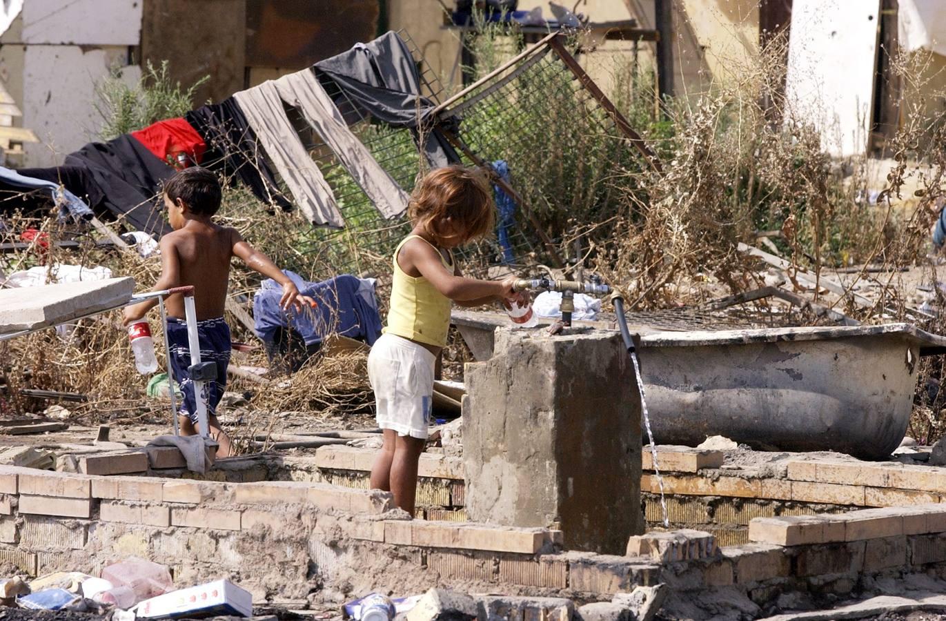 Unos niños recogiendo agua de una fuente en el Vacie, en una imagen tomada en el año 2004