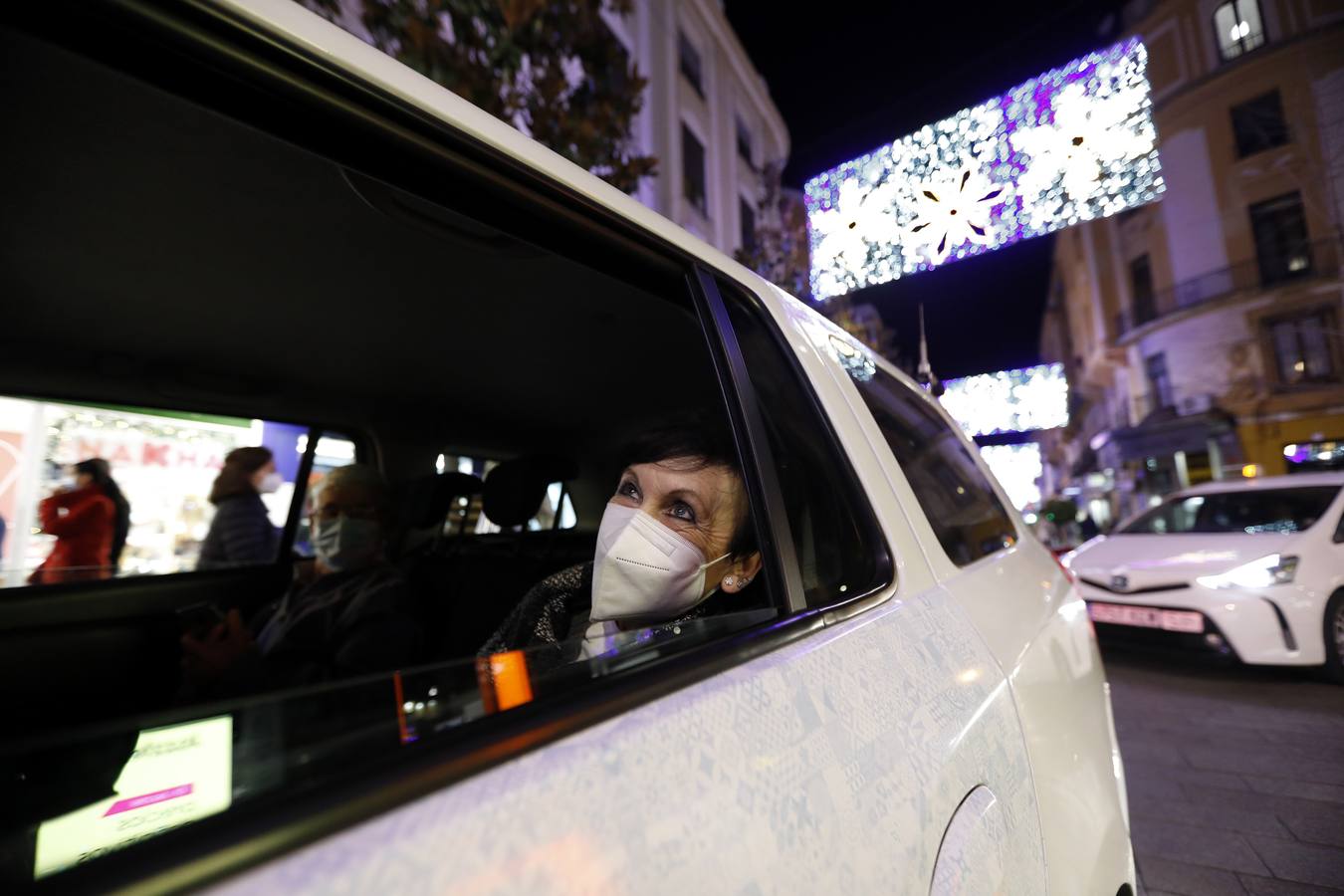 El paseo de los taxistas a los mayores de Alcolea por las luces de Navidad de Córdoba, en imágenes