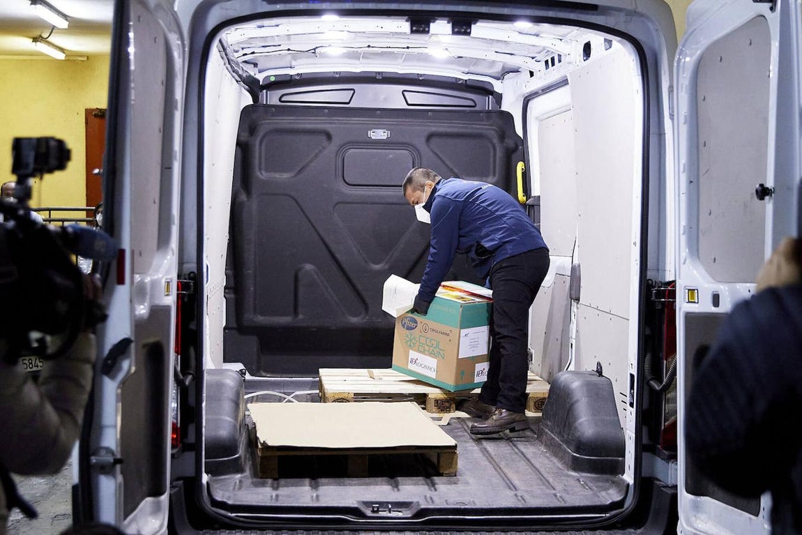 Un operario entrega una caja con dosis de la vacuna de Pfizer y BioNTech en la residencia Los Olmos, la residencia donde se inicia la vacunación contra el Covid-19 en España. 