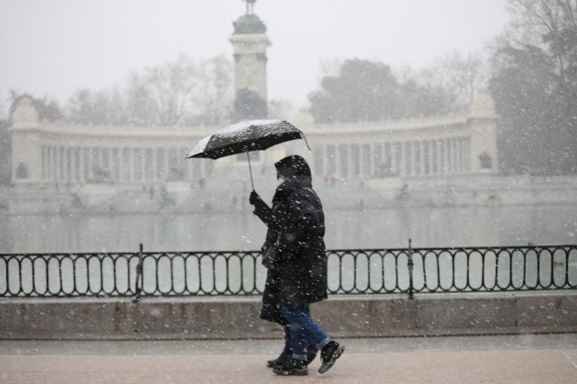 Un viandante camina junto al estanque del Parque del Retiro (Madrid). 