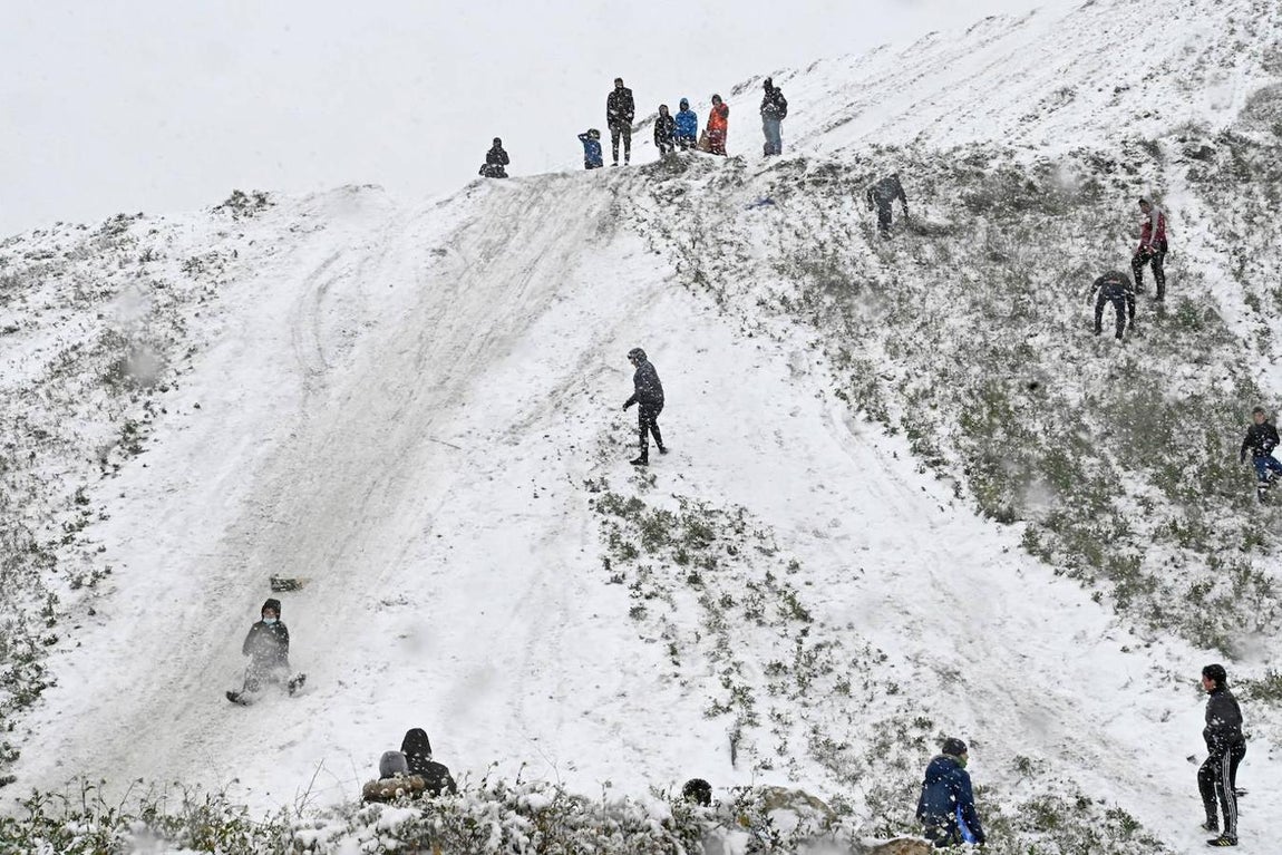 Niños jugando con la nieve en La Cañada, Madrid.  Niños de la Cañada se tiran por un terraplén cubierto de nieve este viernes en Madrid, ciudad azotada, como la mayor parte de la península, por el frío causado por el temporal Filomena