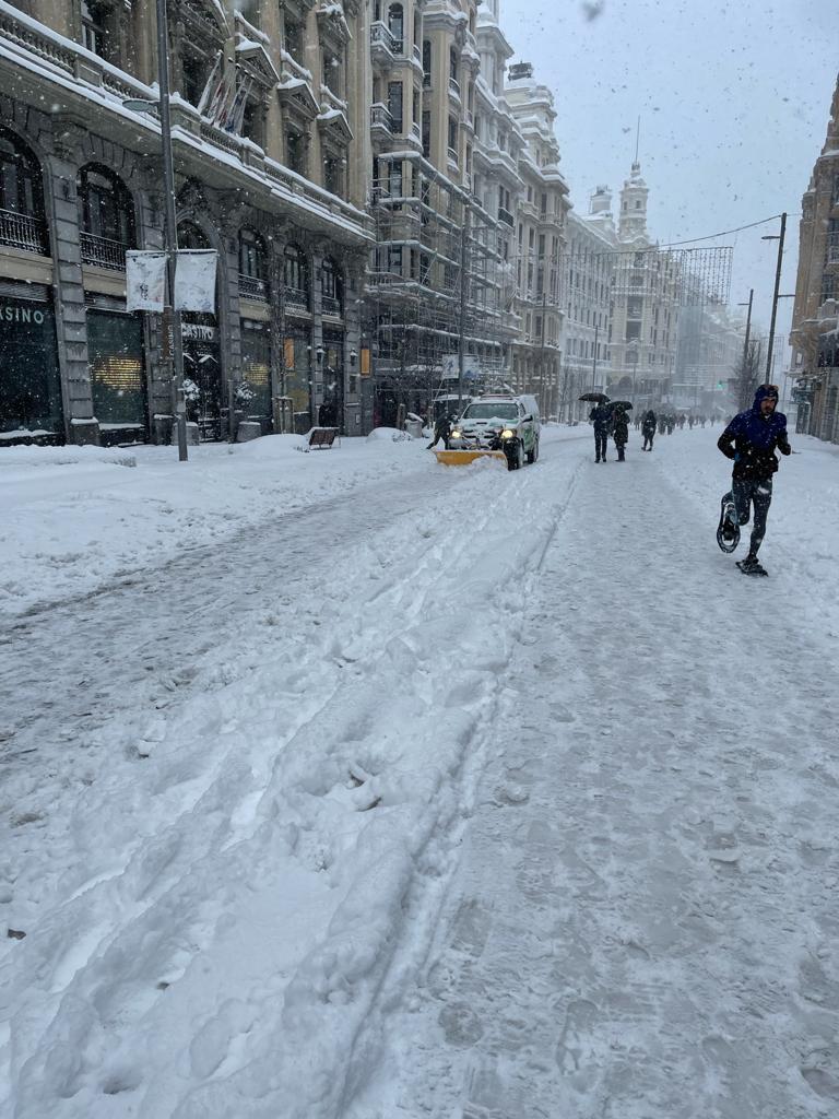 Un ciudadano, corriendo por la Gran Vía de Madrid con raquetas para la nieve. 