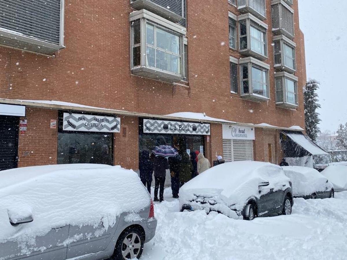 Un puñado de valientes. Una pequeña cola de clientes se ha formado a las puertas de una panaderia del distrito de Hortaleza. El Corte Inglés es una de las grandes cadenas que ha anunciado su cierre durante la jornada, así como algunos supermercados de Mercadona, pero algunos locales pequeños han abierto pese a la nieve.