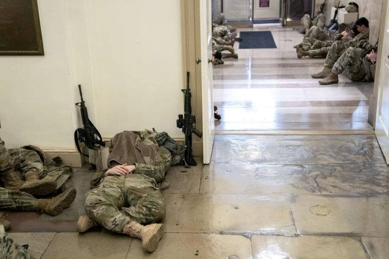 Soldados descansan en los pasillos del Capitolio. La seguridad se ha incrementado en la zona tras el asalto al edificio que se produjo el pasado miércoles y ante la inminencia de la toma de posesión del presidente electo, Joe Biden, el próximo 20 de enero.. 