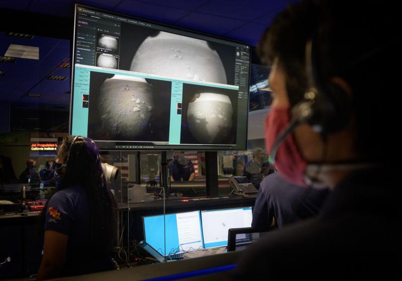 Los miembros del equipo de la NASA observan en el control de la misión cómo llegan las primeras imágenes momentos después de que la nave amartizara. 