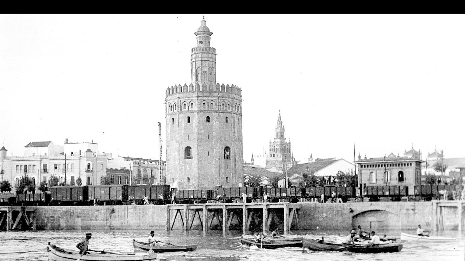 Instantánea de Sevilla en torno al 1950, donde se puede apreciar el ferrocarril que daba servicio justo por delante de la Torre del Oro