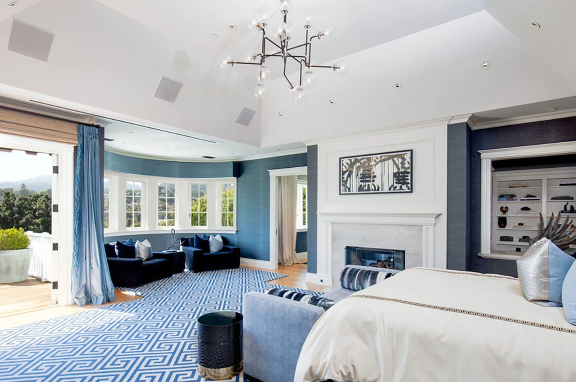 Así es la mansión que vende LeBron James. El dormitorio principal, decorado en tonos azules, incluye una sala de estar, chimenea, acceso directo a una terraza privada, vestidor y un cuarto de baño con un jacuzzi situado justo al lado de un gran ventanal, ideal para tomar una baño tras una jornada de trabajo.