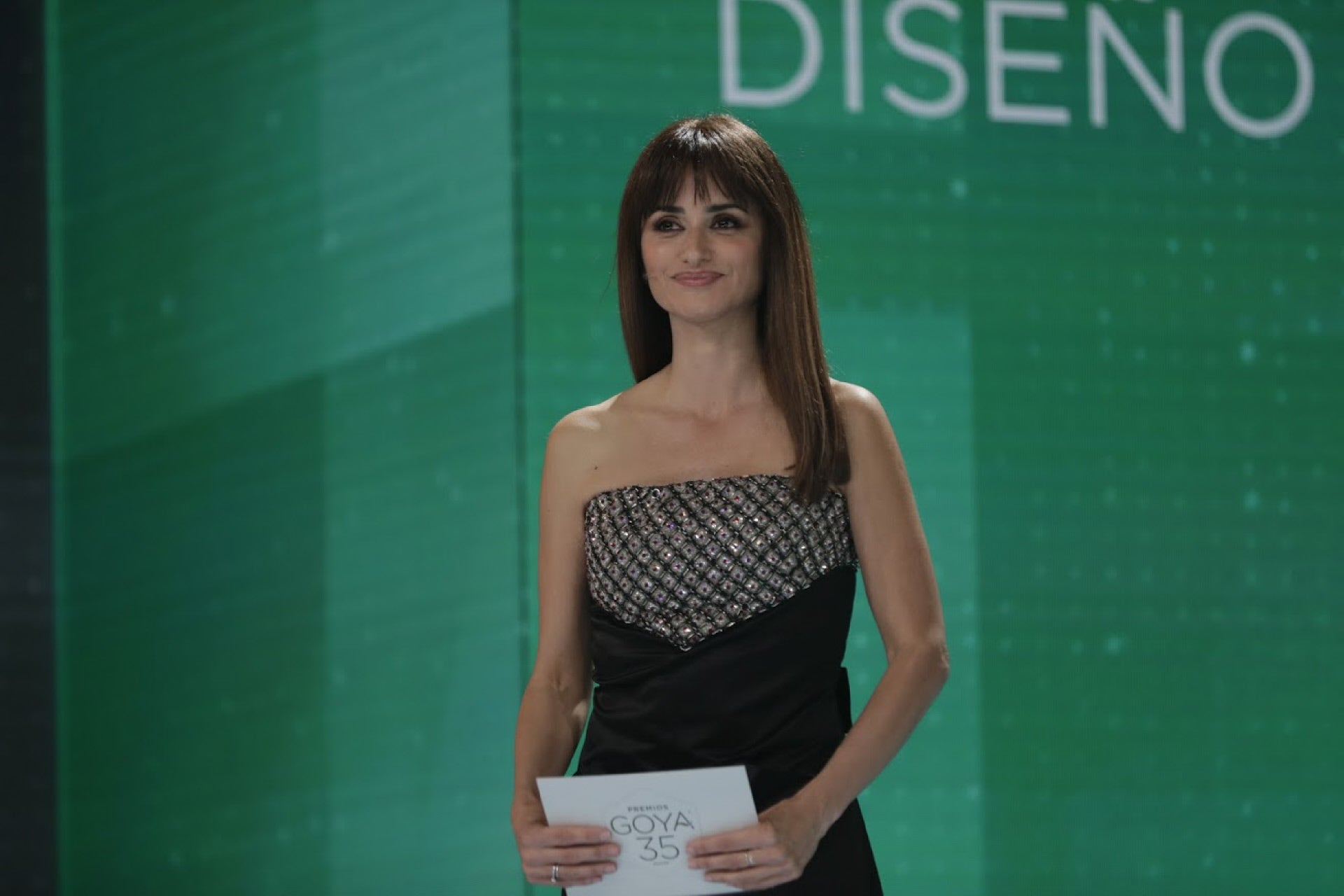 Penélope Cruz, que entregó un Goya, eligió un vestido negro con escote palabra de honor bordado de pedrería en plata. Como es habitual en ella, de Chanel.. 